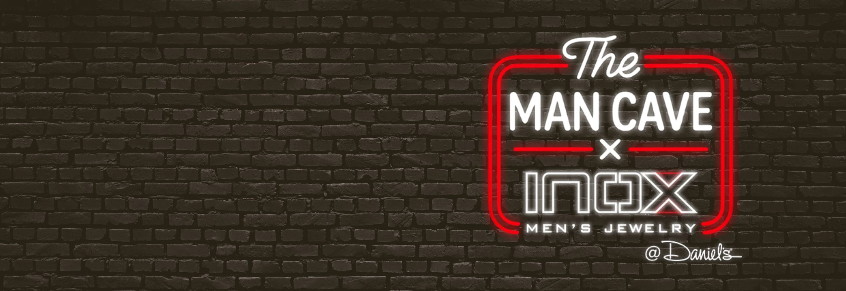 Neon sign of 'The Man Cave x INOX Men's Jewelry' on a brick wall background